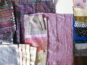 Selection of fabric samples and pieces of fabric, laid out on a table.