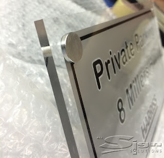 Perspex sign with metal fixing show in the corner.