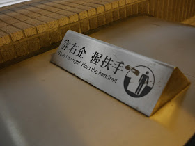 'Stand on right — Hold the handrail' sign on an escalator in Hong Kong