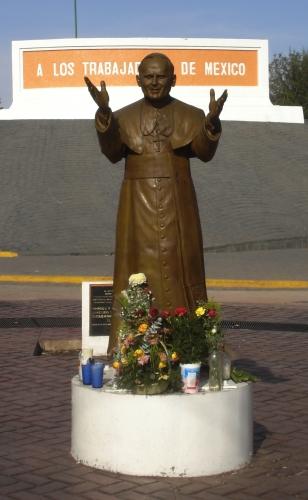 Juan Pablo II Foto a la estatua de Juan Pablo II acompañado de flores