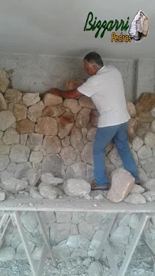 Bizzarri fazendo o revestimento de pedra, com pedra moledo, sendo o revestimento com pedra na parede da adega da residência em Itatiba-SP com essa pedra moledo na cor bege com espessura de 15 a 20 cm.