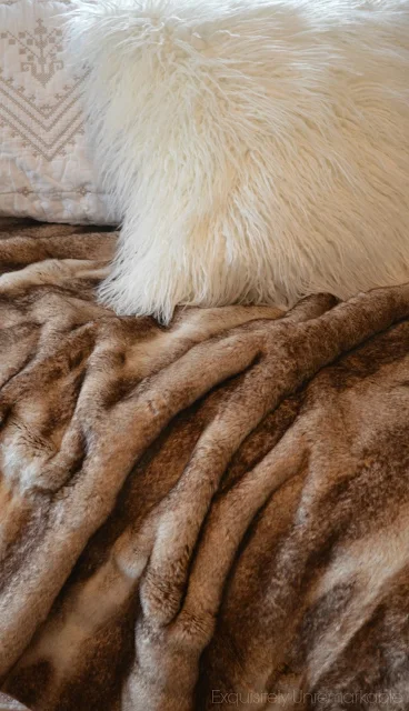 Fur blanket and pillow on a bed