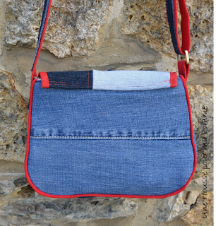 Sac Besace en jeans recyclés monté façon patchwork, intérieur coton étoiles rouges, passepoil (fait-maison) rouge vif, deux poches en soufflet devant, biais rouge sur le rabat, entièrement doublé pour le rendre semi-rigide, anse coton rouge surpiqué avec des morceaux de jeans, boucles couleur laiton. Dimensions : 24 x 18 x 7 cm environ.  Les jeans portés recyclés parfois délavés par le temps apportent cette "petite chose en plus" à cette pièce unique