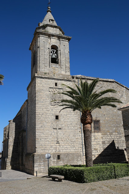 Antigua iglesia de pueblo con campanario, un día con cielo azul de fondo.