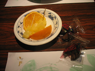 A dish of oranges, pineapple, and fortune cookies
