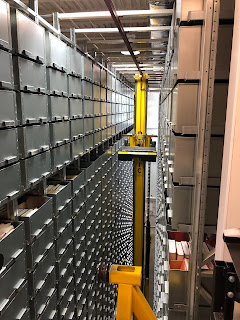 automated storage retrieval crane and stacks of book storage drawers