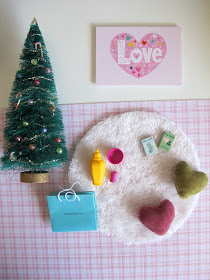 Selection of modern miniature dolls' house accessories in shades of pink, green and white.