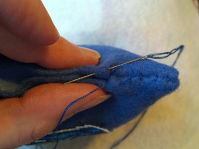 Place the next stitch on the opposite side of the seam, overlapping the end of the last stitch