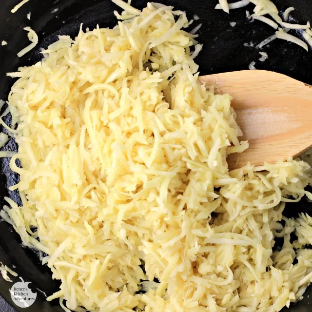 Shredded parsnips in pan with spatula