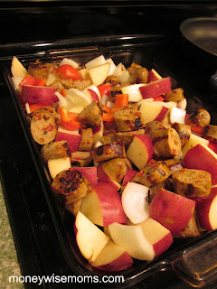 uncooked sausage and cut vegetables in glass baking dish