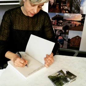 Rebecca Hawcroft signs a copy of her book The Other Moderns.