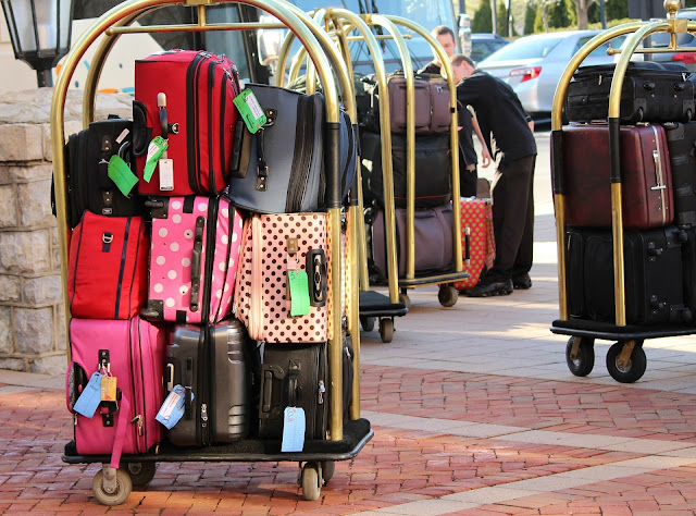 luggage outside of a hotel building waiting to be rolled inside. 