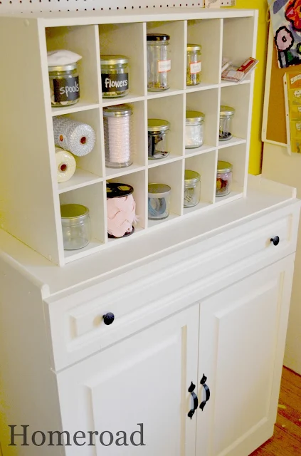 White cubbie shelf on top of white wooden cabinet