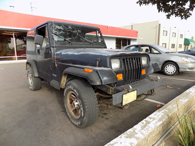 Jeep Wrangler with faded, peeling paint before repairs at Almost Everything Auto Body.