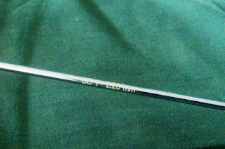The shaft of a metal dpn held against a green background.  Text on the dpn reads US 1 2.25 mm