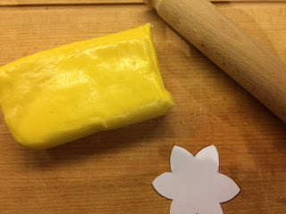 Marzipan on a wooden board, rolling pin and daffodil template