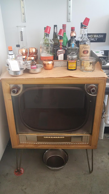 Bar, booze on top of old TV, bicycle shop