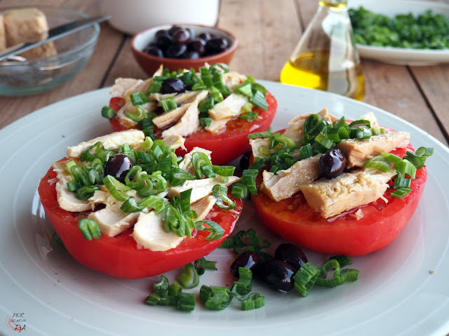 Ensalada que combina gruesas rodajas de tomate maduro, atún en aceite, olivas negras y los tallos verdes de las cebolletas frescas, aromatizado con orégano y aceite de oliva