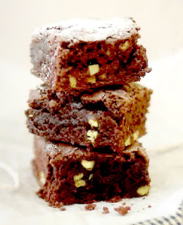 Stach of chocolate brownies dusted with icing sugar