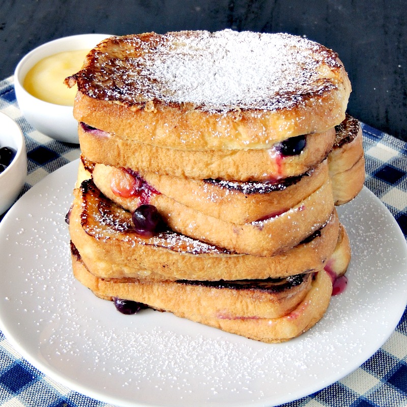 Lemon Blueberry Stuffed French Toast on a white plate with a blue and white checkered place mat.