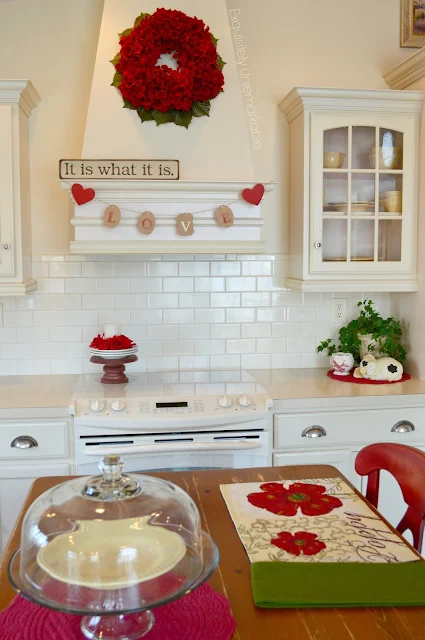 Bisque Painted kitchen with red accents and gift tag banner on on hood