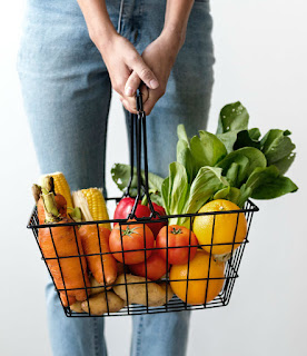 Basket of fruit and veg Woman holding wire basket full of fruit and vegetables