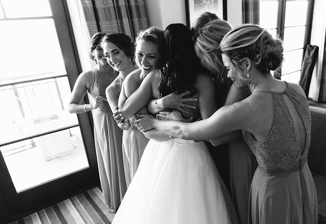 bridesmaids hugging bride