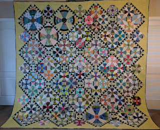 This scrap quilt features many conversational prints, scale change of block, sawtooth sashing