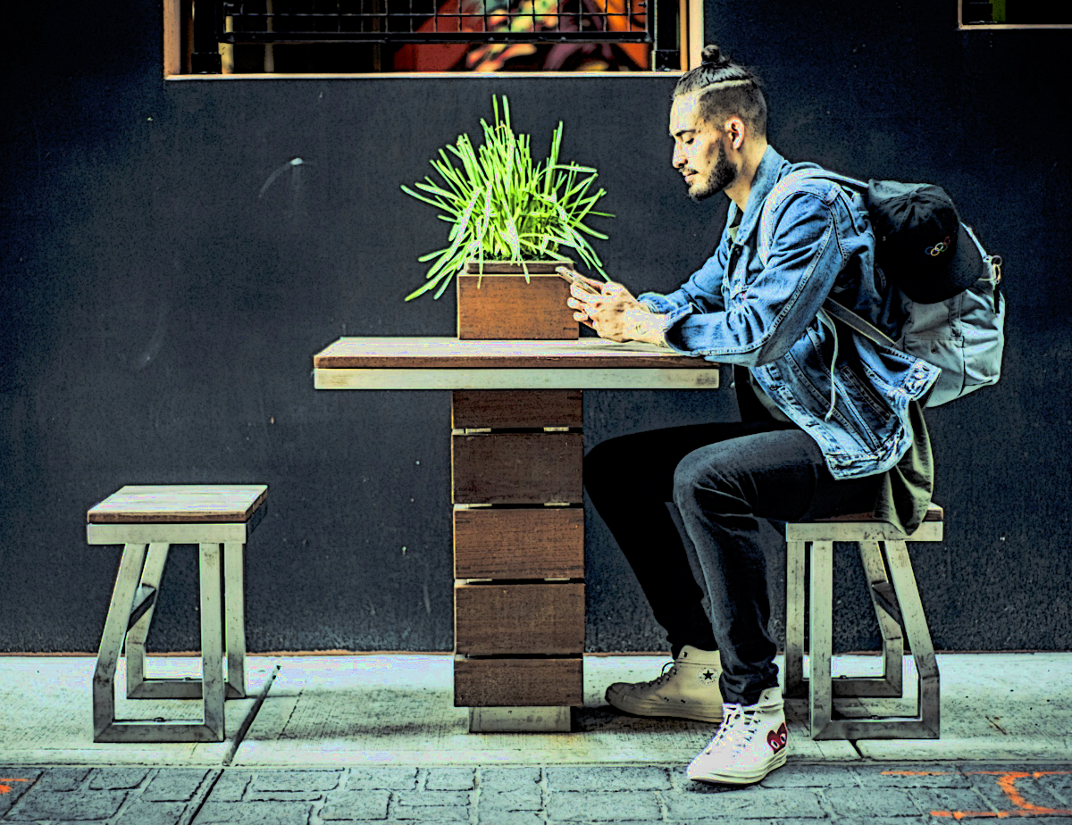 millennial sitting at table texting