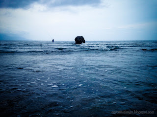 Fisherman And Chunk Of Coral Reef And In The Middle Of The Shallow Seawater At Umeanyar Beach, North Bali, Indonesia