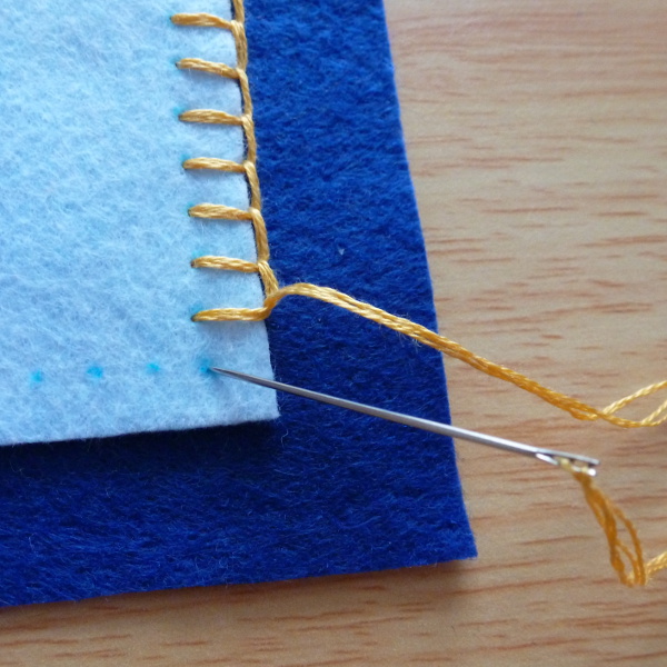 Sewing stitches around a square corner of felt