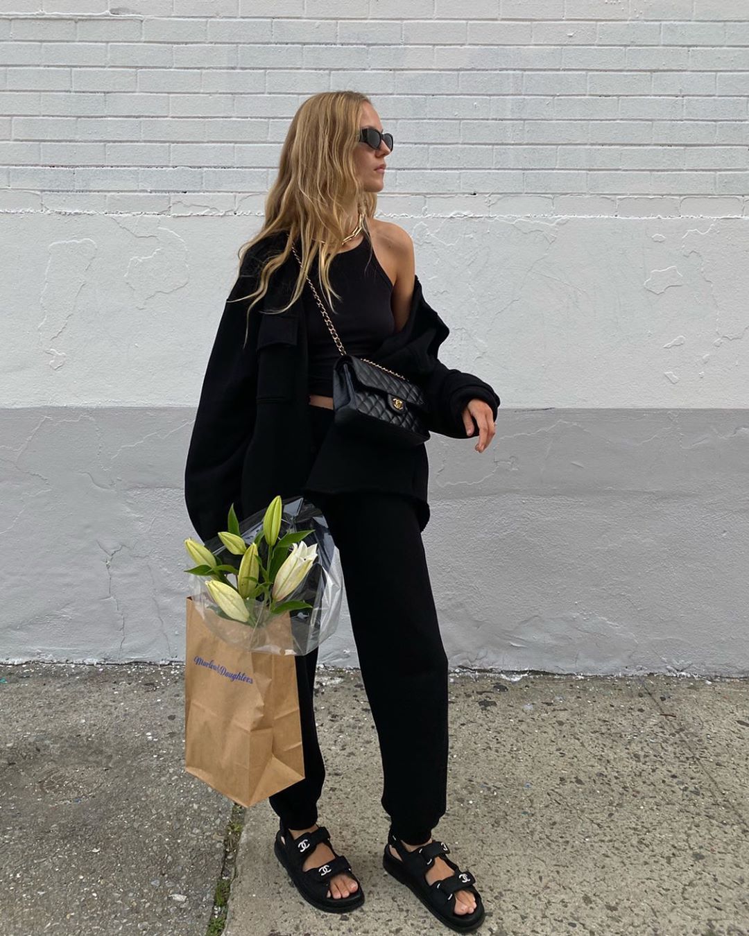 Marie von Behrens @mvb Instagram all-black outfit idea: sweatshirt, tank top, Chanel bag, sweatpants, and Chanel dad sandals