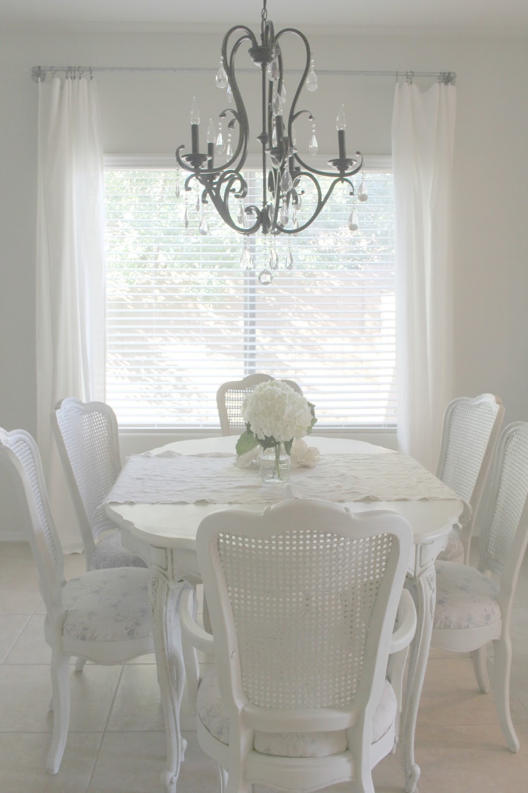 Beautiful serene shabby chic dining room with cane back chairs by Hello Lovely Studio