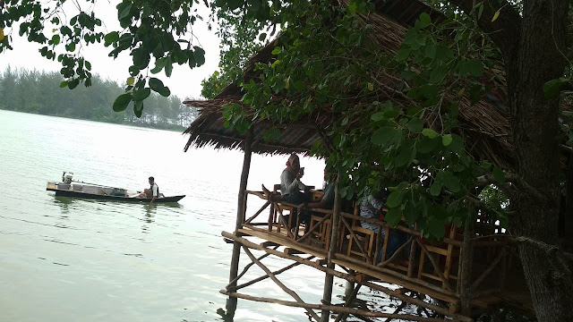 pondokan dan perahu kecil di atas sungai mangrove