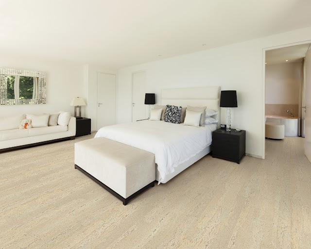 Light grey wood flooring adds an element of style to this bedroom. 