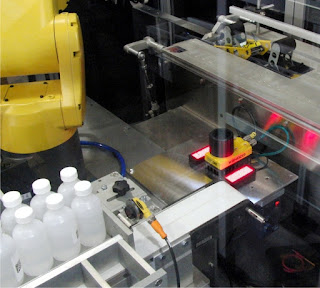 ESS Technologies Robotic Case Packer with Integrated Serialization Camera for inspecting serialization codes on bottles.