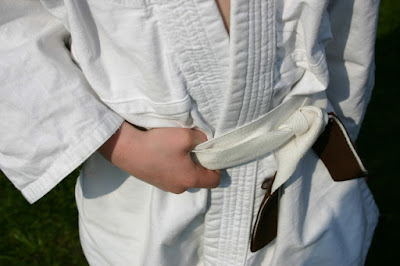 The Spirit Of Judo: Image of the torso of a person in a Judo Gi with white belts