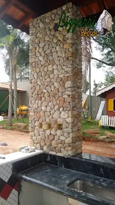 Execução de revestimento com pedras do rio nos pilares de concreto em residência em Itatiba-SP.