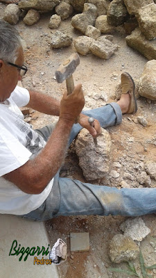 Bizzarri preparando as pedras moledo para iniciar o revestimento de pedra na parede da adega com pedra moledo.