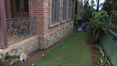 Base da casa com execução do revestimento de pedra com pedra moledo tipo chapas em casa com parede de tijolo a vista em condomínio em Atibaia-SP.