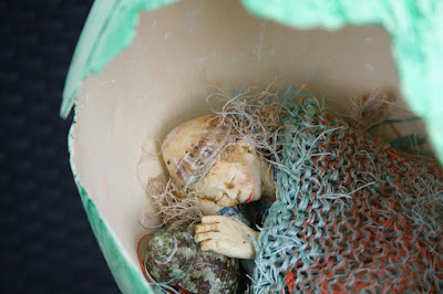 Detail of sculpture Aerial  by Corina Duyn, figure sleeping in pod 