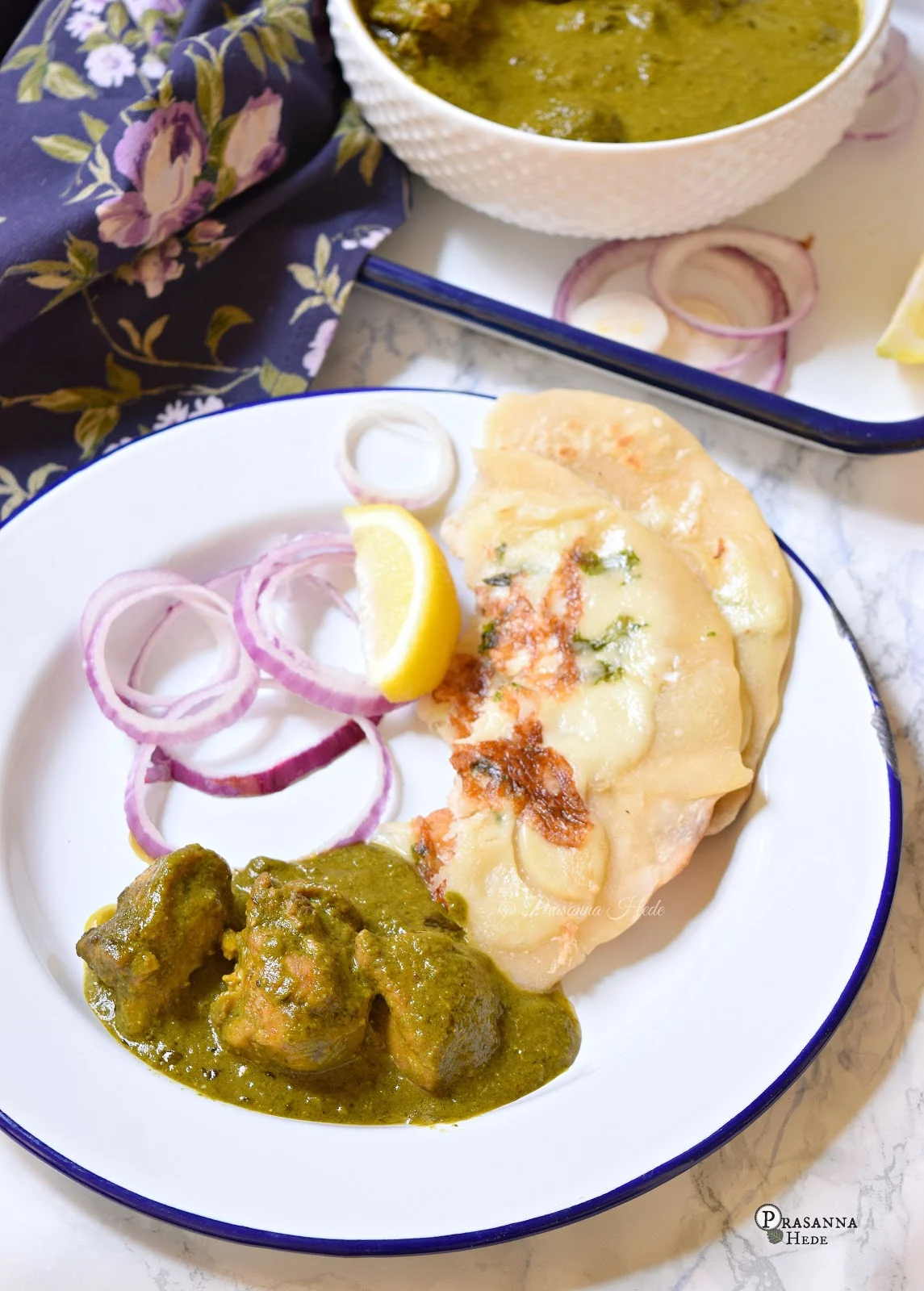 A closer look of white plate with spinach chicken curry and naan