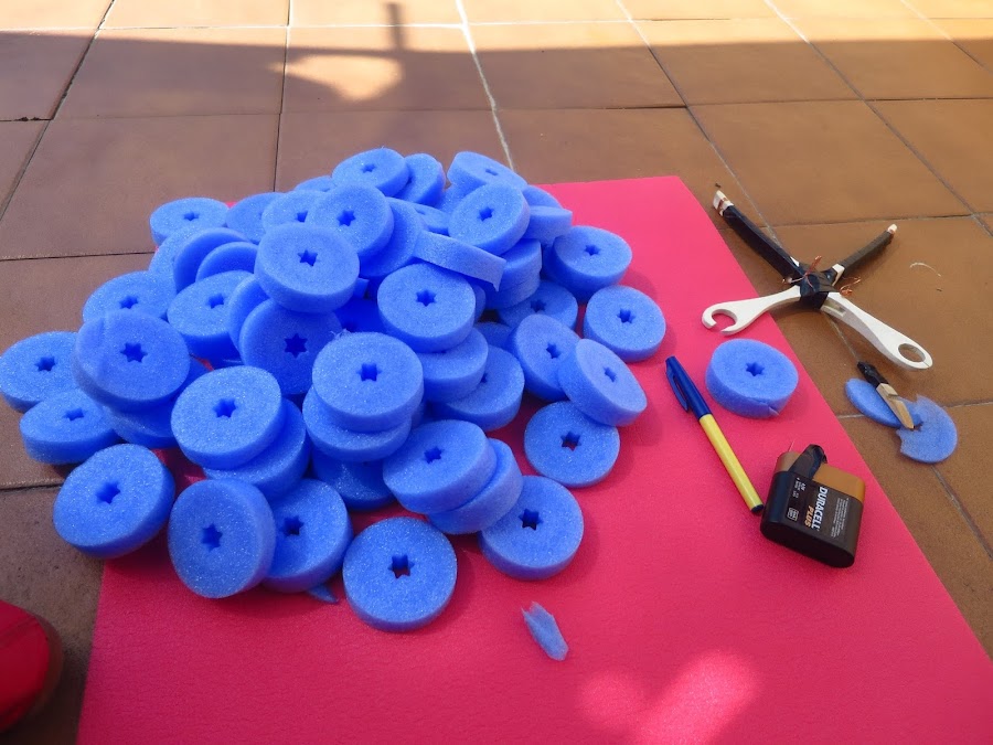 para cortar el churro de piscina utilizamos una pistola casera para cortar poliespan. Tenemos un monton de rodajas del churro