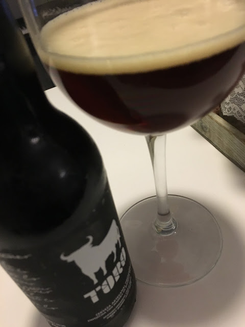 Cerveza Toro. Oscura y espuma ambar.