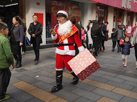 person in Santa outside looking at their mobile phone while walking
