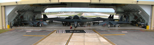 Two B-2 Spirit bombers and four F-15E Strike Eagles are parked inside Hangar 1 at Andersen Air Force Base, Guam.