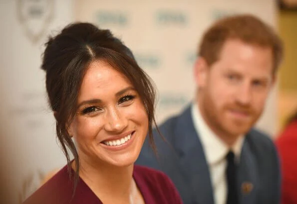 Meghan Markle wore Joseph pullover, Hugo Boss Selrita leather skirt, Sarah Flint pumps and Emily Mortimer Hera gold and diamond earrings