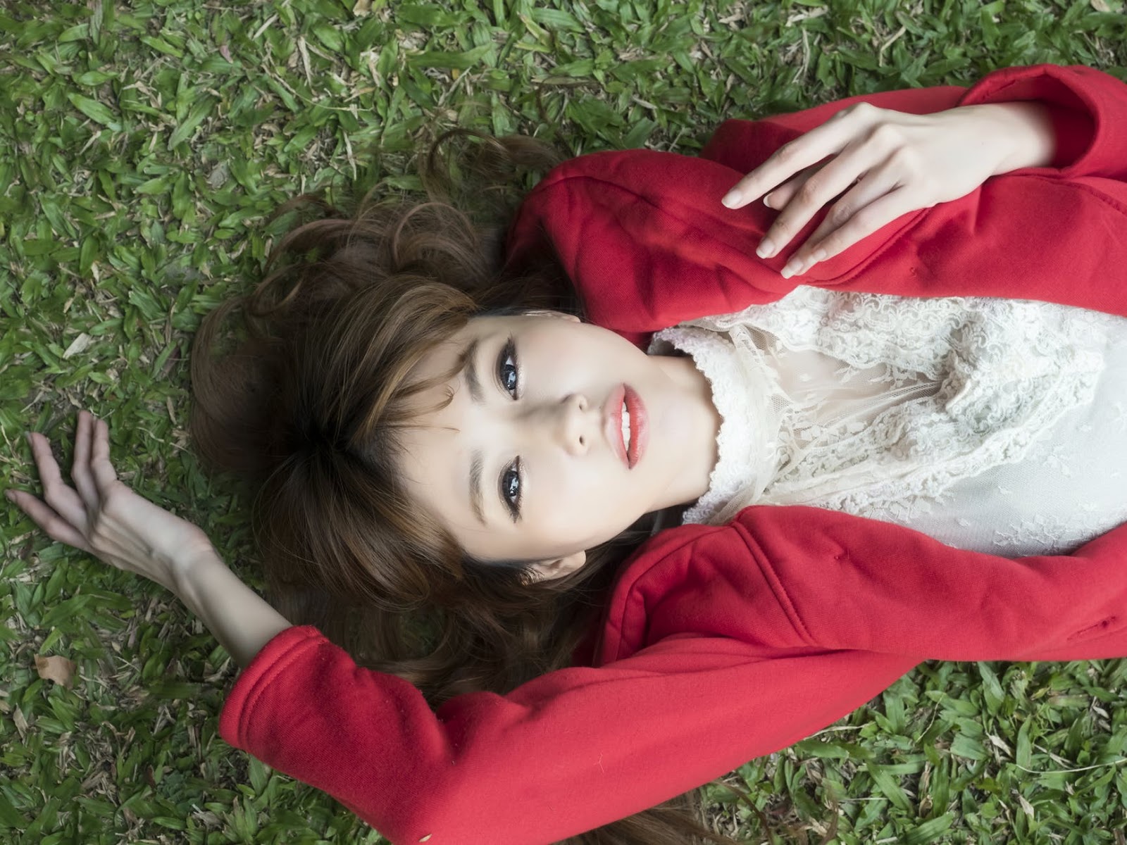 White Shirt Wearing Red Blazer Lying on Green Grass