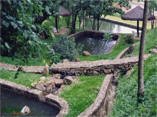 Execução do caminho de pedra rústica com a construção dos lagos, os muros de pedra rústico com a execução do quiosque de piaçava com a execução do paisagismo.