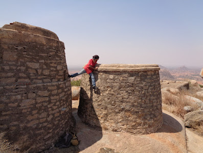 Sippy playing around the ancient granaries used to store water, grains or oil at the summit of medigeshi